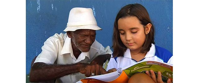 Criança ensina a ler e a escrever vendedor de picolé que trabalha há 40 anos em escola e história viraliza